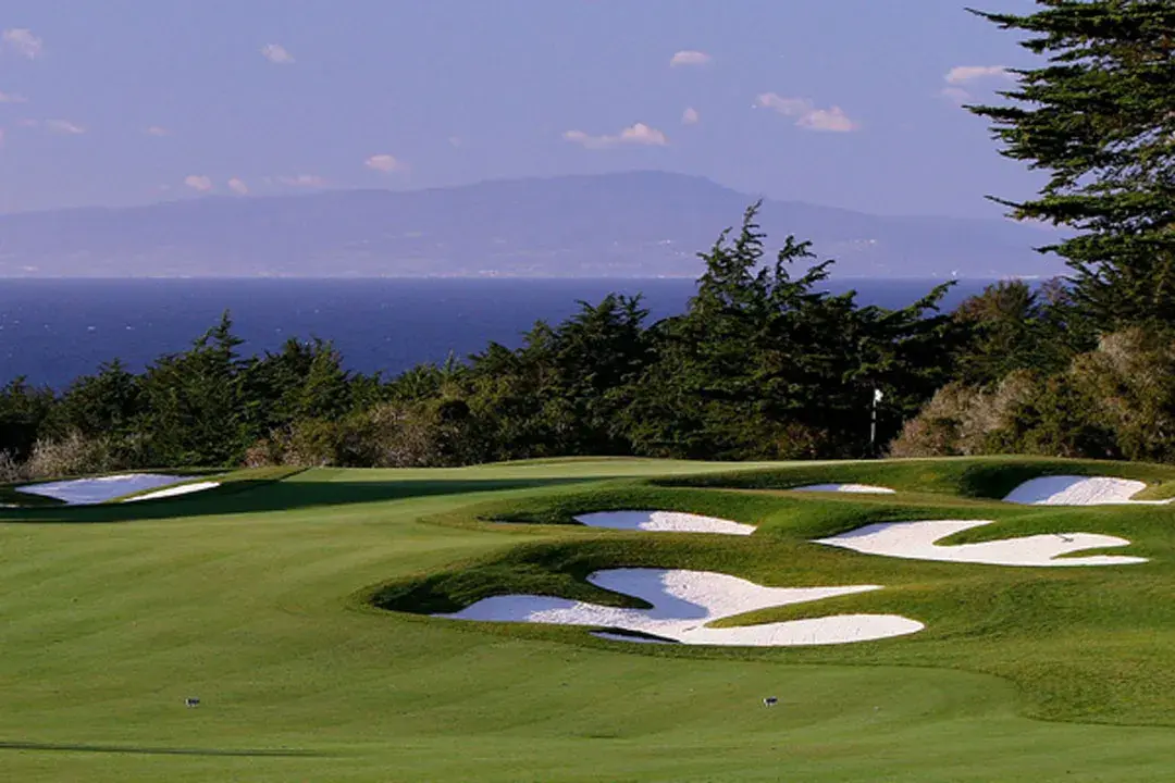 Elevated approach shots with distant Monterey Bay views on the back nine.