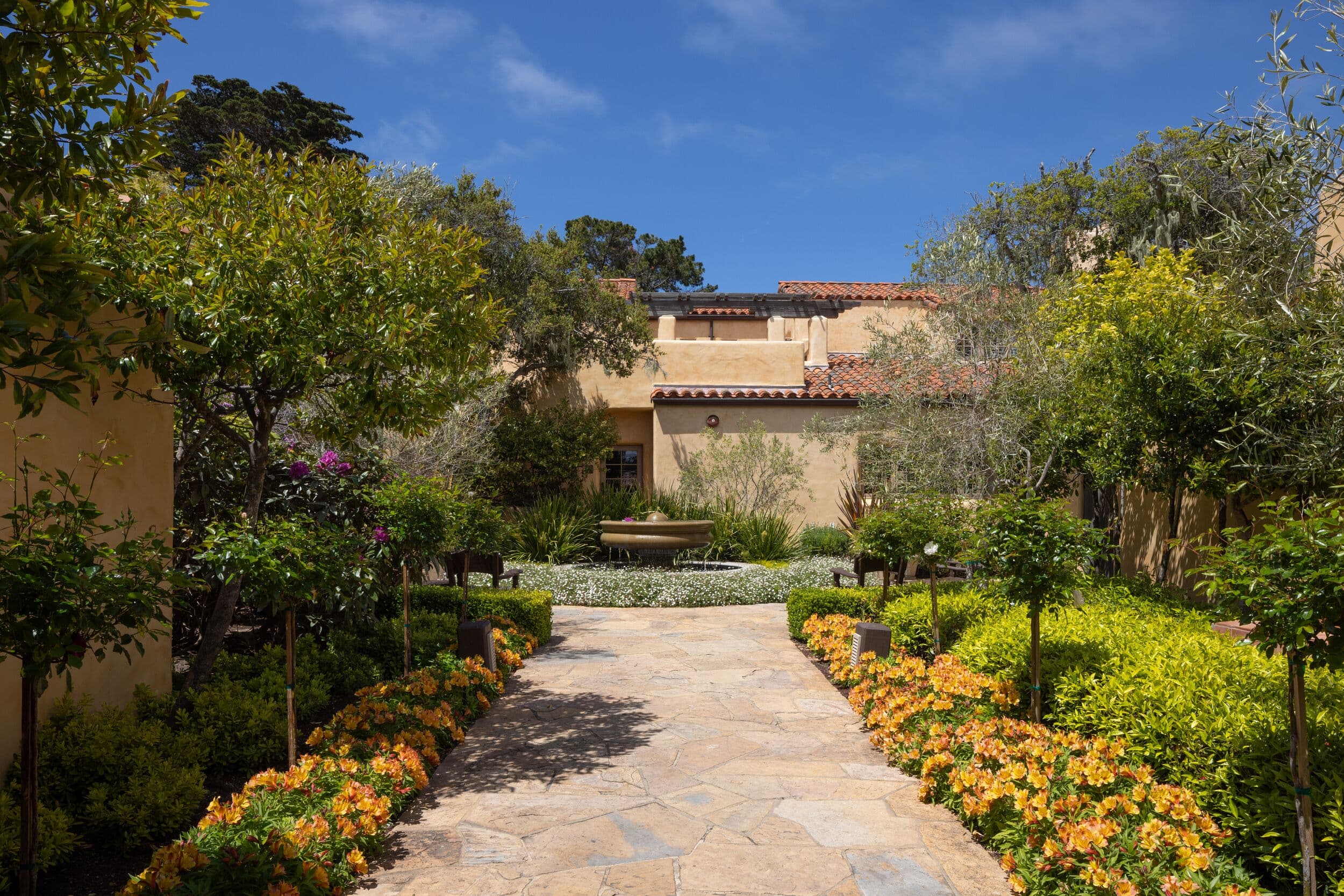 Casa Palmero™ garden walkway with fountain, Pebble Beach, CA — stone path through manicured gardens